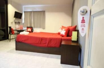 Modern bedroom with red bedding and amenities