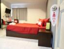 Modern bedroom with red bedding and amenities