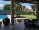 Covered outdoor patio with view of pool and garden