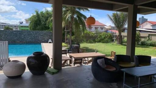 Covered outdoor patio with view of pool and garden