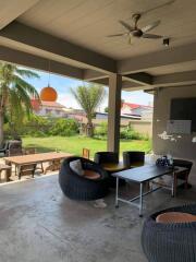 Spacious outdoor living area with modern furniture and tropical view