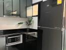 Modern kitchen with black appliances and cabinets