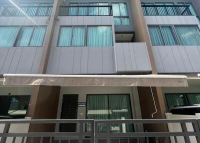 Three-story modern townhouse with balconies and large windows