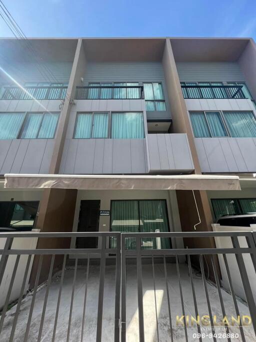 Three-story modern townhouse with balconies and large windows