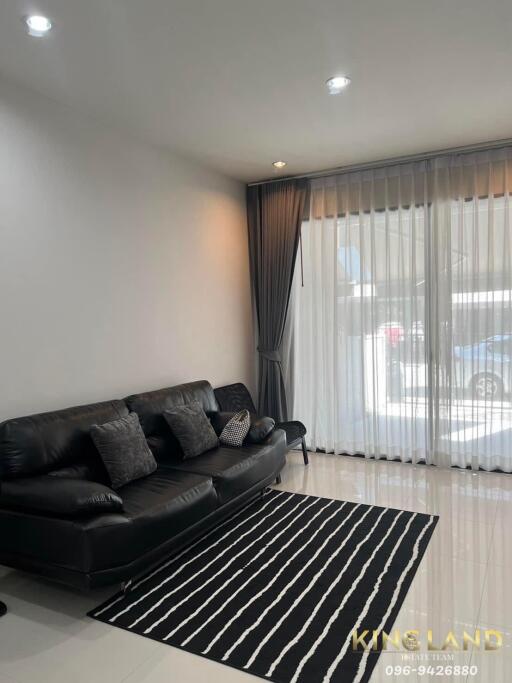 Modern living room with black sofa and striped rug