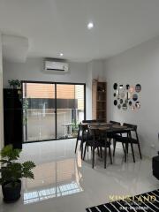 Modern dining area with large sliding glass doors, mirror wall decor, and indoor plants