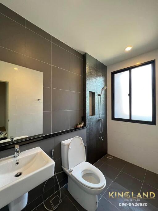 Modern bathroom with sink, toilet, shower, and large window