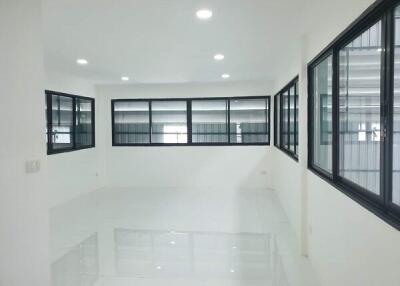 Empty white room with multiple windows and tile flooring