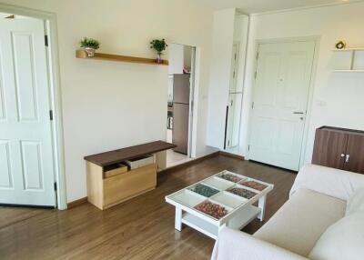 Modern living room with wooden floor, white walls, and minimalistic furniture