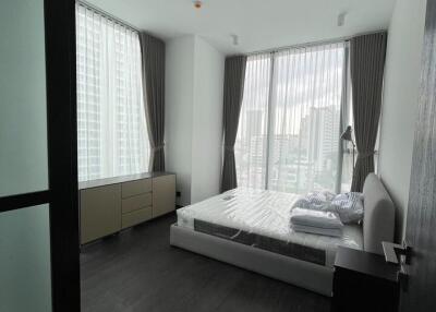 Modern bedroom with large windows and city view