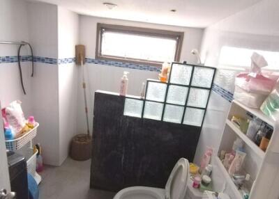 Small bathroom with storage shelves and a glass block partition