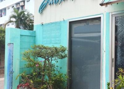 Building exterior with potted plants and sign