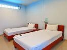 Two single beds in a brightly lit bedroom