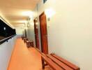 Long hallway with wooden doors and benches