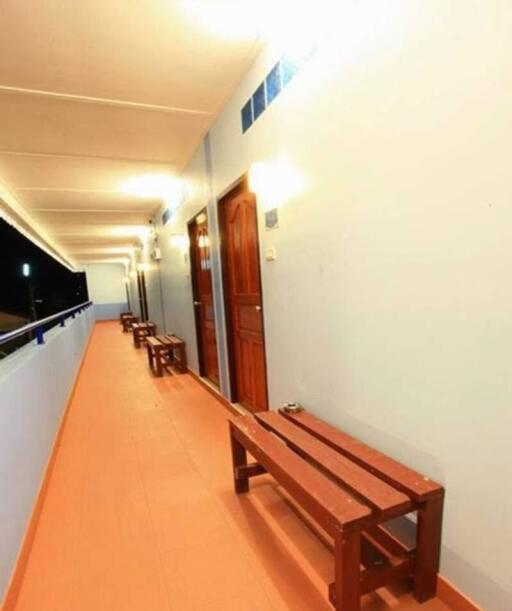 Long hallway with wooden doors and benches