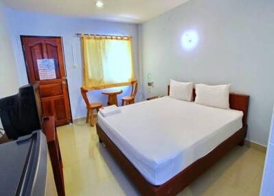 Well-lit bedroom with a double bed, wooden furniture, and window