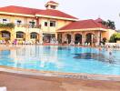 Outdoor swimming pool with surrounding lounge chairs and a large building in the background