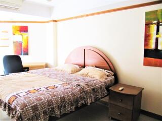 Cozy bedroom with a double bed, artwork, and study area