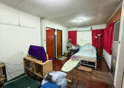 A bedroom with various furnishings and household items