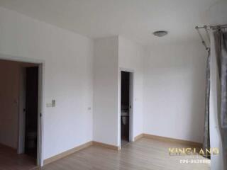 Spacious bedroom with wooden flooring and natural light from the window