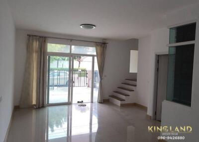 Spacious living room with large windows and staircase