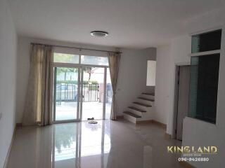 Spacious living room with large windows and staircase