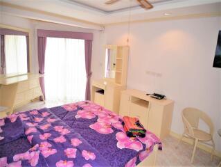 Bright and cozy bedroom with purple floral bedding and ample storage