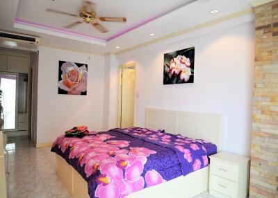 Bright bedroom with floral decorations and ceiling fan