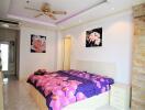 Bright bedroom with floral decorations and ceiling fan