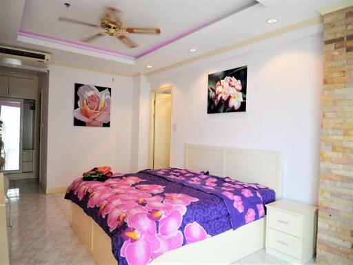 Bright bedroom with floral decorations and ceiling fan