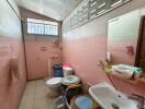 Bathroom with pink tiles and basic amenities