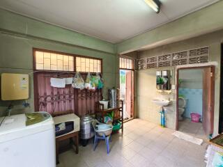 Spacious kitchen area with appliances and free-standing sink