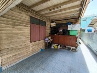 An exterior storage area with wooden walls and miscellaneous items