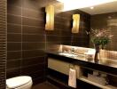 Modern bathroom with dark tiles, floating sink, and decorative lighting