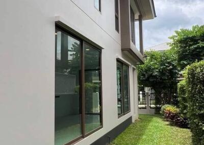 Exterior view of a modern building with large windows and green lawn