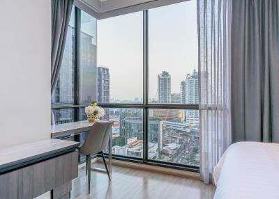 Bedroom with large windows and city view