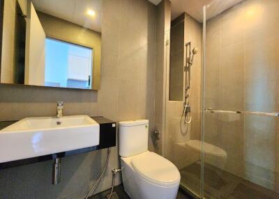 Modern bathroom with glass shower enclosure and wall-mounted sink