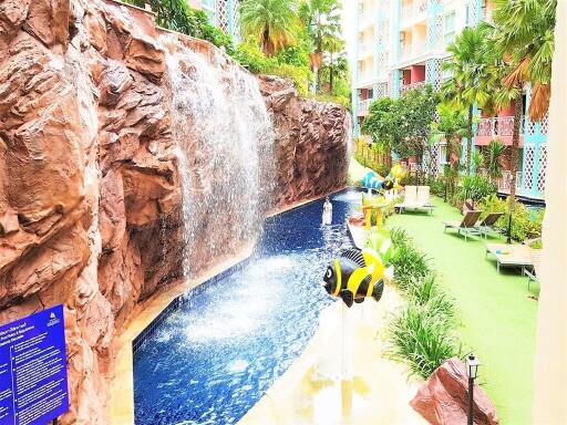 Outdoor swimming pool with waterfall feature and lounge area