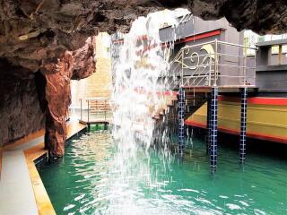 Pool area with waterfall feature inside cave-like setting