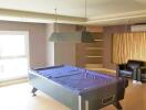 A recreational room with a pool table and seating area