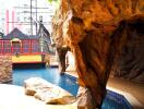 Outdoor pool area with rocky overhang and adjacent decorative ship