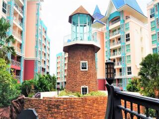 Exterior view of residential buildings with a unique tower structure, balconies, and landscaping