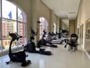 Well-equipped gym with modern exercise machines and large windows