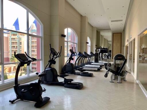 Well-equipped gym with modern exercise machines and large windows