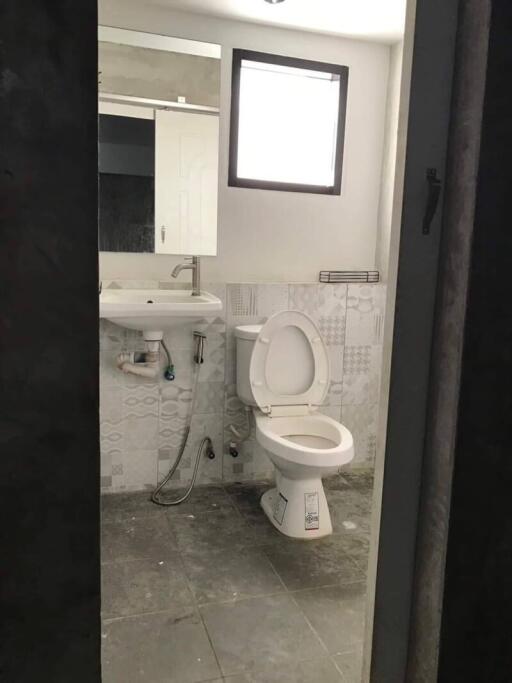 Bathroom with toilet, sink, and small window