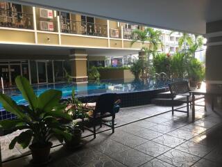 Outdoor pool area with seating and greenery