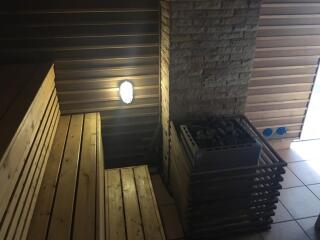 Interior view of a sauna with wooden benches and a heater