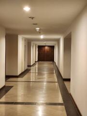 Hallway with wooden door and tile flooring