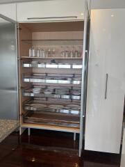 Modern kitchen cabinet with glass shelves and organized tableware