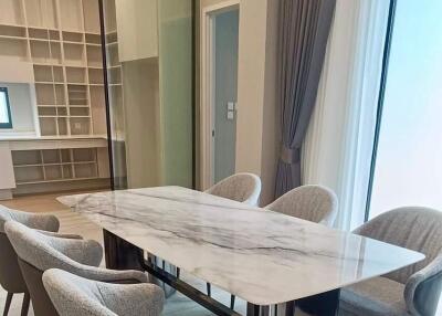 Modern dining area with a marble table and six upholstered chairs